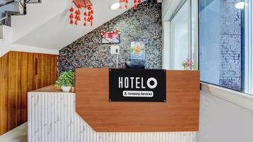 Un taulell de recepció d'hotel amb acabat de fusta i disseny semblant a marbre.