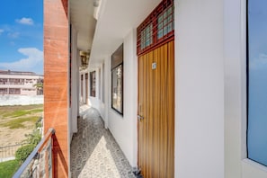 A corridor with a wooden door labeled 'A7' and a window on the right. - Super OYO Hotel O Rakabganj Crossway (Faizabad)