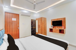 A hotel room with a bed, wardrobe, TV, and an air conditioning unit. - Super OYO Hotel O Rakabganj Crossway (Faizabad)
