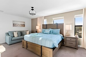 A modern bedroom with a large bed, a sofa, a nightstand, and a ceiling light. - 6BR Storey Lake Villa w/ Pool, Spa & EV Charger (Kissimmee)