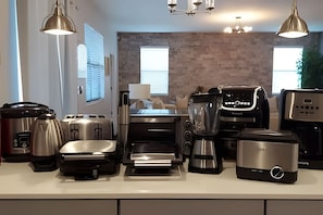 A modern kitchen with stainless steel appliances, including a coffee maker, toaster, and kettle. - 6BR Storey Lake Villa w/ Pool, Spa & EV Charger (Kissimmee)