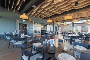 A modern restaurant interior with multiple dining tables, chairs, and hanging pendant lights. - Residencial Exclusive - Santa Rosalia Lake Resort (Torre-Pacheco)