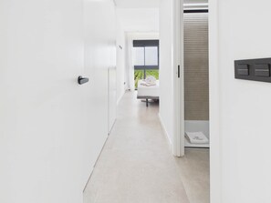 A modern hotel corridor with a bed and a window in the background. - Residencial Exclusive - Santa Rosalia Lake Resort (Torre-Pacheco)