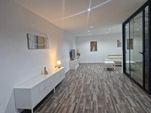 A modern living room with a white console, a television, and a sofa. - The Marina Oasis - Santa Rosalia Lake Resort (Torre-Pacheco)