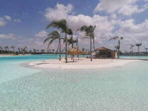A beach resort with clear turquoise waters, palm trees, and a small hut. - The Marina Oasis - Santa Rosalia Lake Resort (Torre-Pacheco)