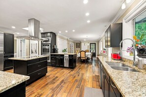 Una cocina moderna con encimeras de granito, electrodomésticos de acero inoxidable y una isla central.