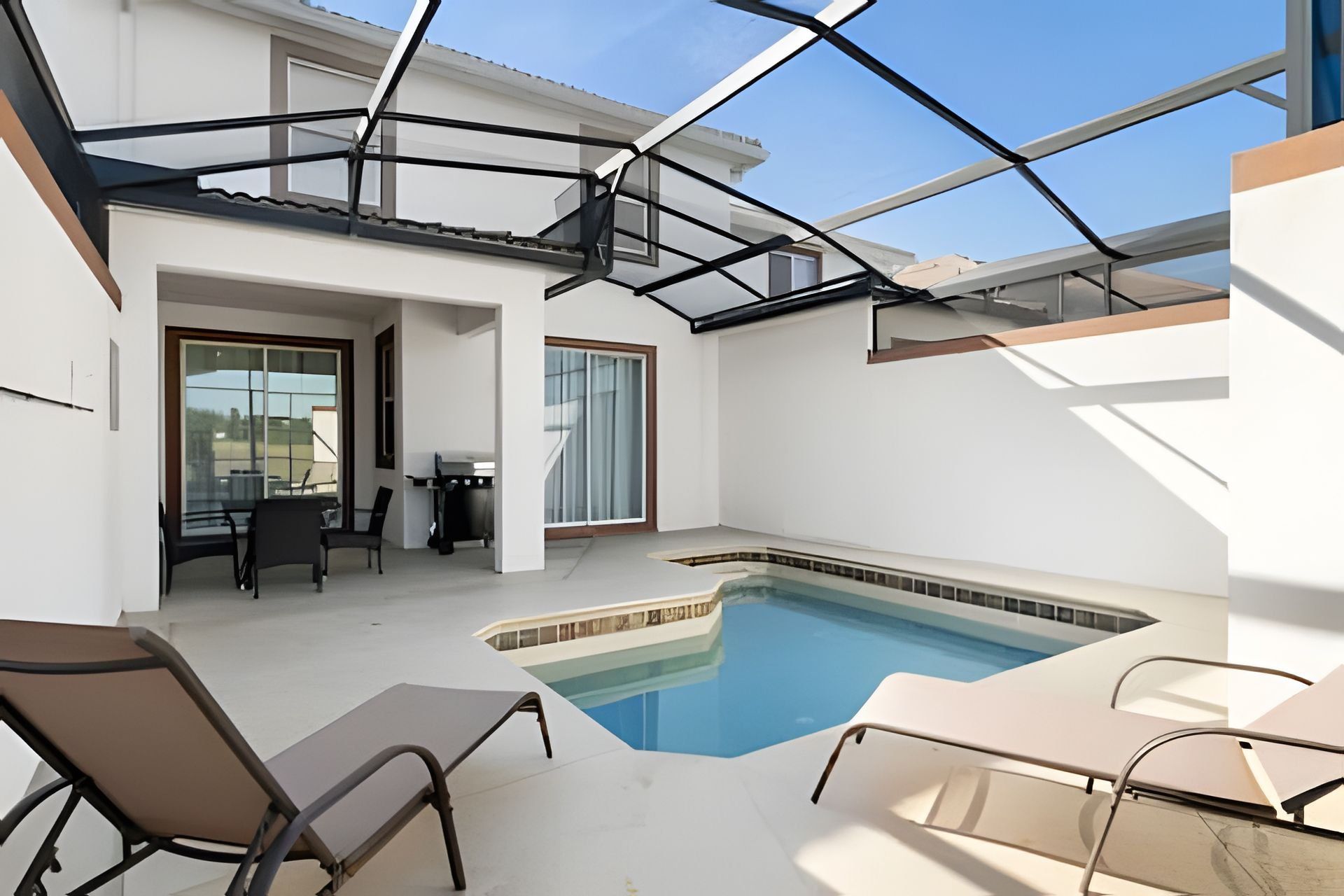 Un espace piscine extérieur moderne doté d’un toit en verre, d’une table de billard et de chaises longues.