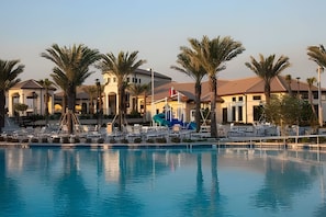 A resort with a swimming pool, palm trees, and a building with a dome roof. - 4BR w/ Mickey & Mario Rooms + Heated Pool (Davenport)