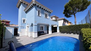 A two-story building with a swimming pool, outdoor seating, and a clear blue sky. - Villa Oliver - Mar Menor Golf Resort (Torre-Pacheco)