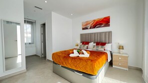 A modern hotel room with a large bed, a bedside table with a lamp, and a painting on the wall. - 7LakesVilla - Santa Rosalia Lake Resort (Torre-Pacheco)