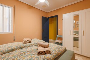 Ein Schlafzimmer mit zwei Betten, einem Kleiderschrank und einer Tür zu einem anderen Raum.