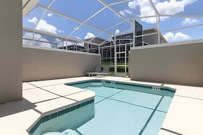 A modern indoor pool with a glass ceiling, surrounded by white walls and a clear view of the sky and buildings. - 4BR w/ Pool + Mickey & Star Wars Rooms (Davenport)