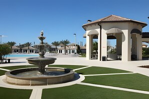 A fountain in a courtyard with a pool and a gazebo. - 4BR w/ Pool + Mickey & Star Wars Rooms (Davenport)