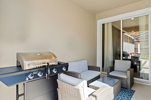 A balcony with a grill, seating, and a view of the interior. - Disney-area 4BR Townhome w/ Heated Pool (Davenport)