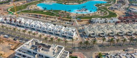 A modern residential area with a central swimming pool, surrounded by multi-story buildings with balconies.