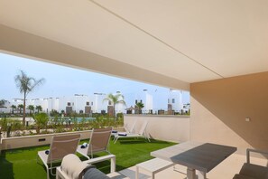 Eine Dachterrasse mit Pool, Liegestühlen und einem Tisch.