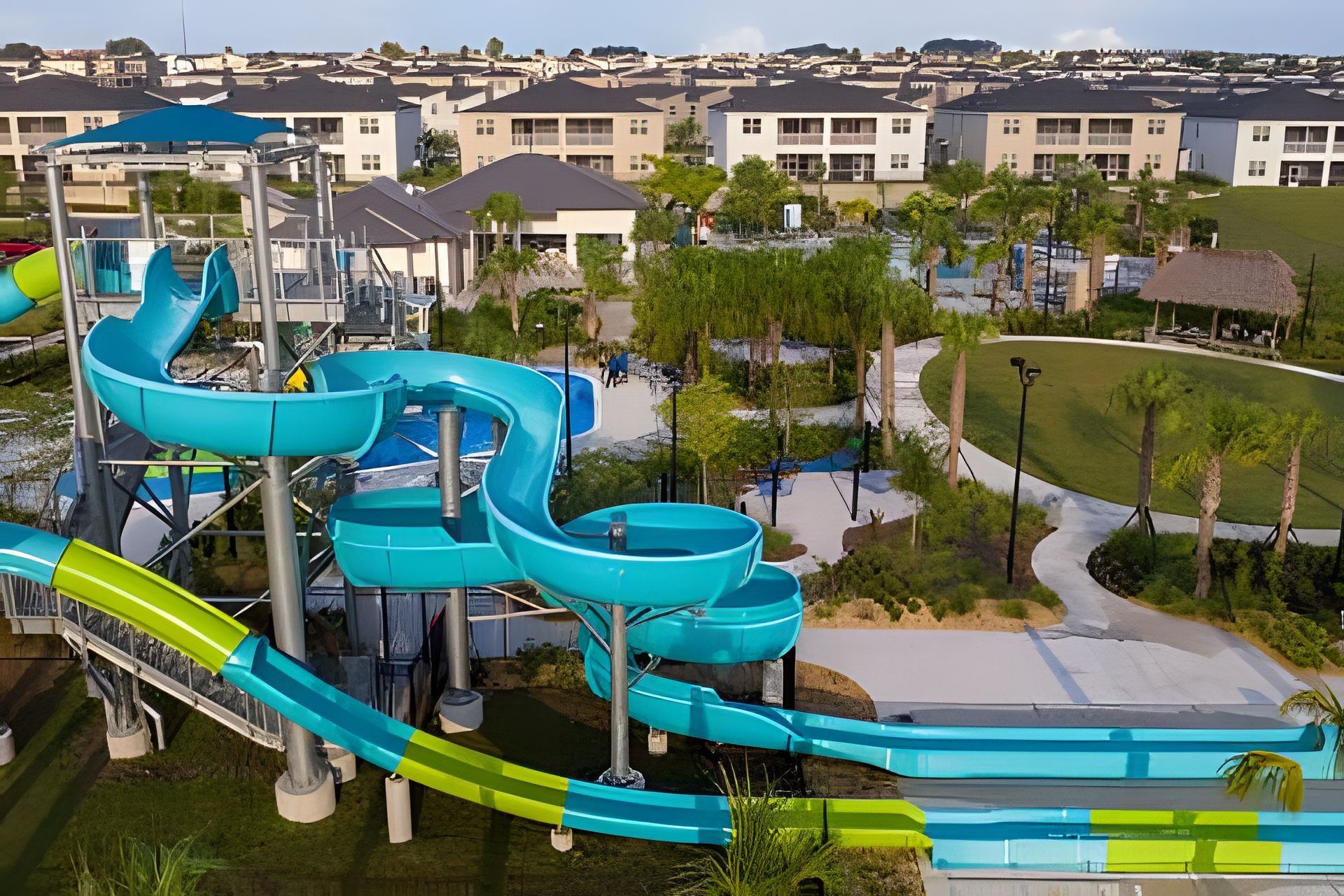 Parque acuático con múltiples toboganes y zona de piscina, rodeado de edificios residenciales.