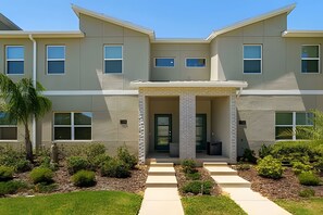 A modern two-story building with a symmetrical facade, large windows, and a central entrance with a covered porch. - Championsgate 4BR w/ Pool, Themes, Near Disney (Davenport)