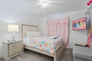 Ein Schlafzimmer mit Bett, Nachttisch, Lampe und einem Bild an der Wand.