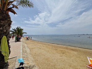 A beach with palm trees, a sandy shore, and a calm sea. - Luxury Holiday Home Berlin - San Pedro del Pinatar (San Pedro del Pinatar)