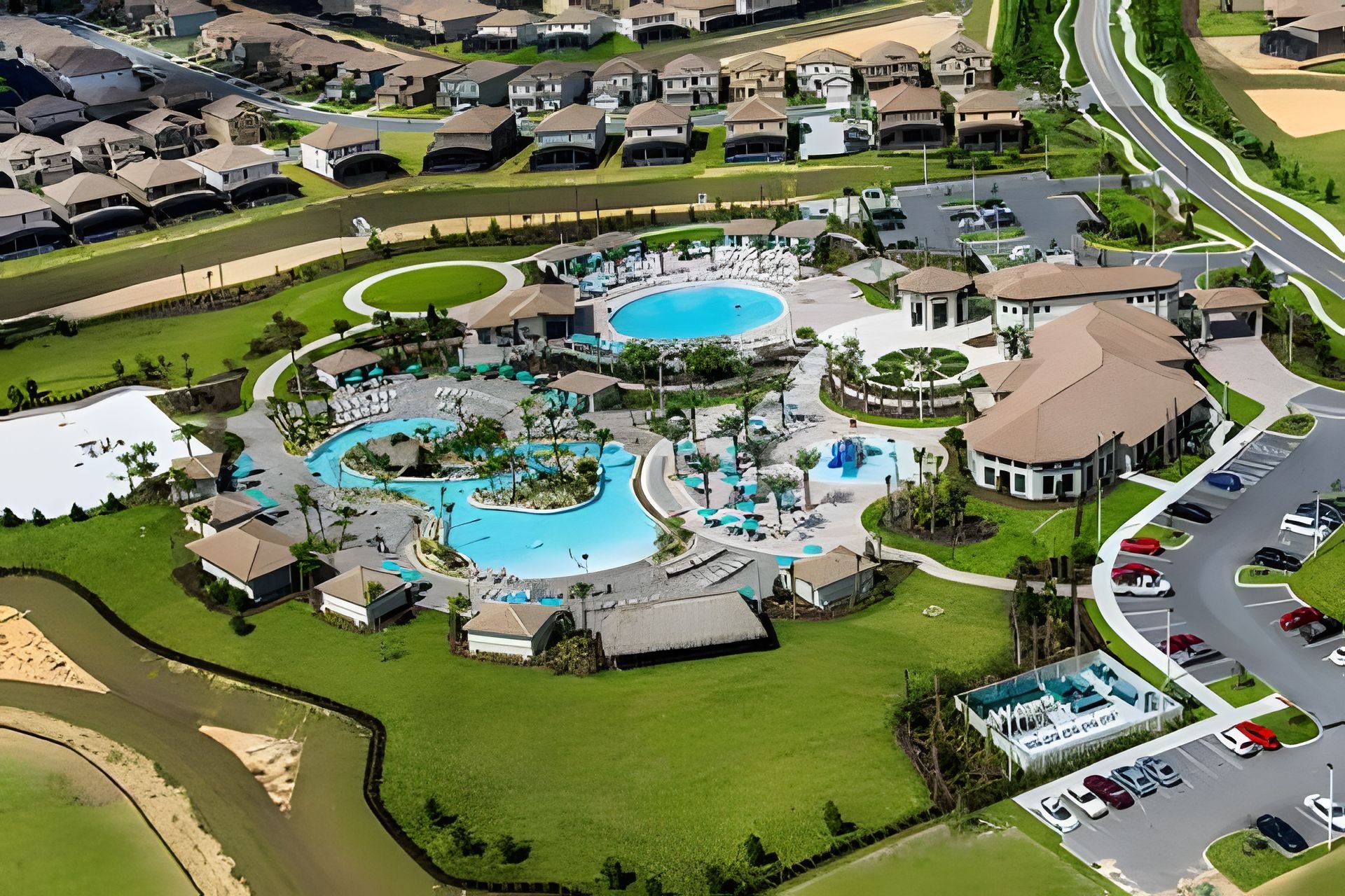 An aerial view of a residential area with multiple swimming pools, a golf course, and a parking lot.