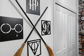A wall with framed pictures and broomsticks crossed over them. - 5BR Home w/ Pool, Game Room + Near Disney (Davenport)