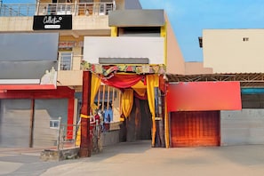 A storefront with a metal gate, a signboard, and a building facade. - Collection O Meerut City Junction (Meerut)