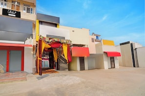 A building with a storefront featuring colorful drapery and a signboard. - Collection O Meerut City Junction (Meerut)