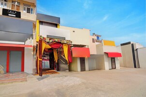 A building with a storefront featuring colorful drapery and a signboard.