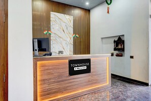 Un mostrador de recepción con un cartel que dice 'TOWNHOUSE' y 'YO-Serviced'.