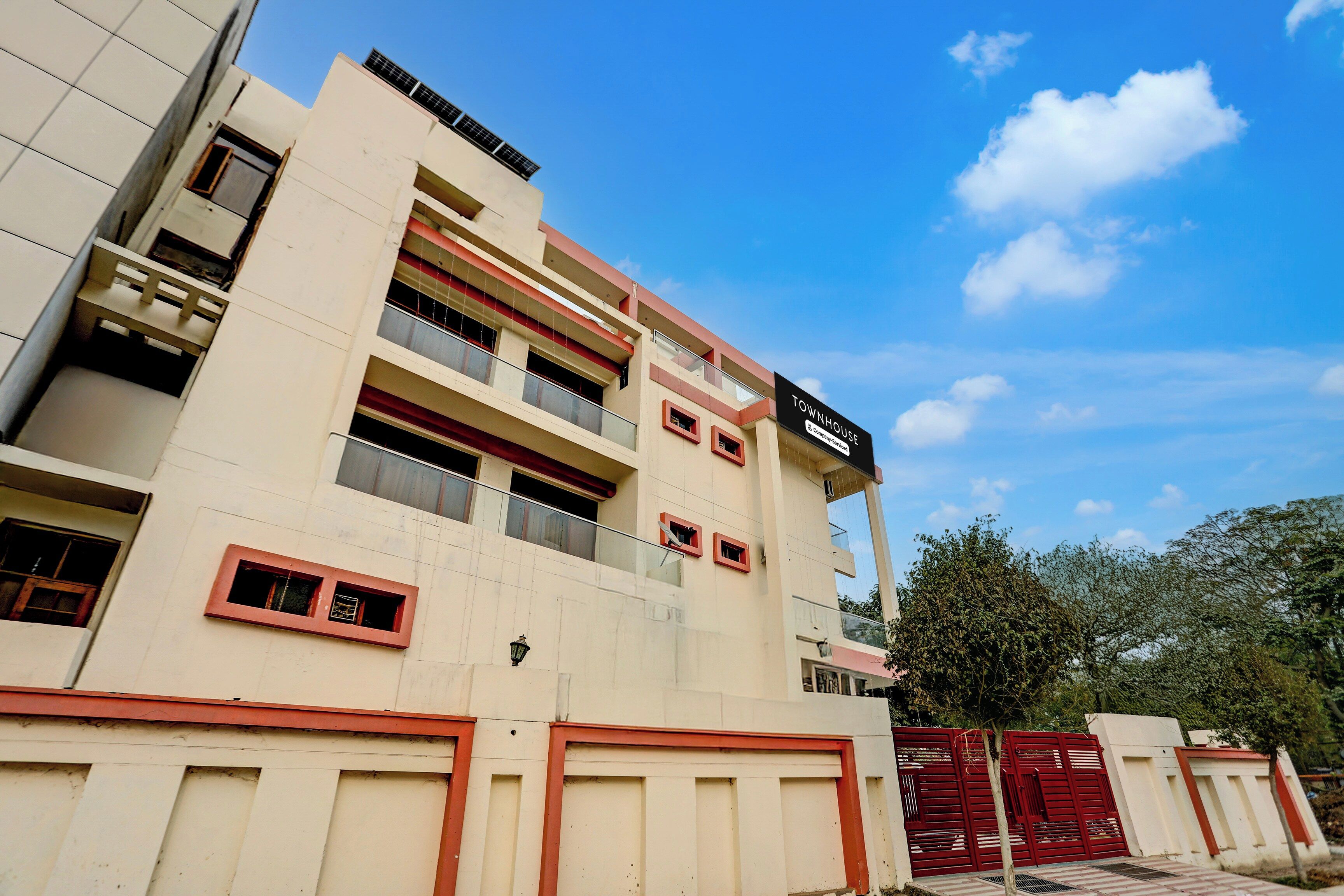 A multi-story building with a sign reading 'TOWNHOUSE' and a gated entrance.