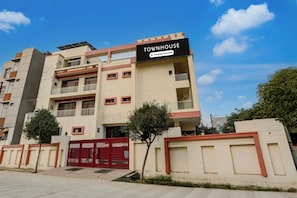 Un edificio de varios pisos con un letrero que indica que es una casa adosada con servicios de empresa.