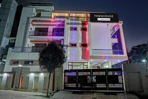 Un moderno edificio de varios pisos con un letrero que dice 'TOWNHOUSE' y 'Company Serviced'.