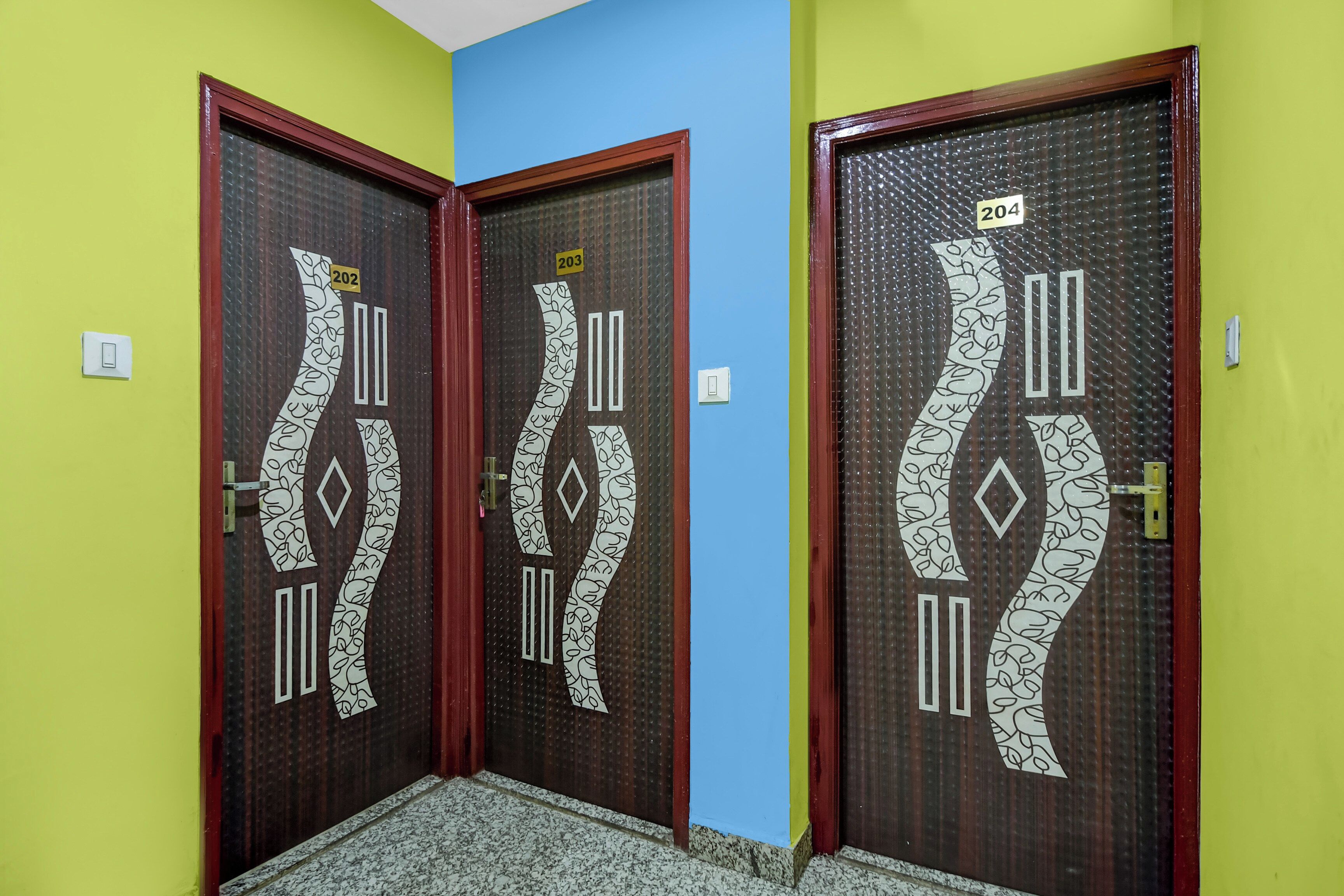 Two doors with decorative patterns and numbers, set in a hallway with a tiled floor.