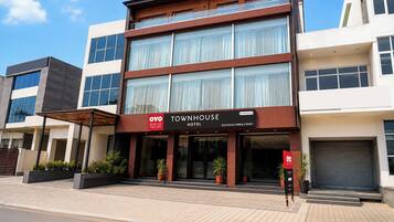A modern hotel with a prominent sign for 'Townhouse Hotel' on the ground floor.