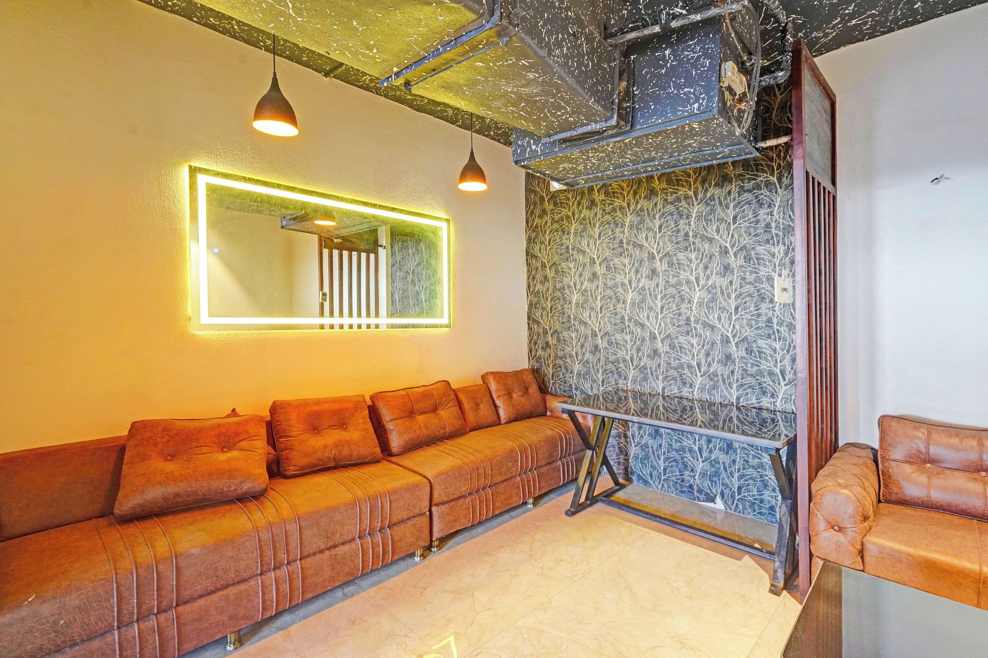A modern interior with a sectional sofa, a mirror, and a patterned wall.
