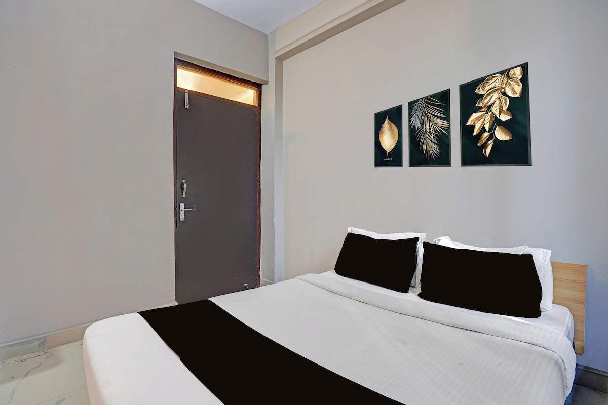 Een slaapkamer met een bed, een deur en drie kunstwerken aan de muur.