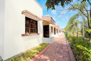 A pathway leading to a row of white buildings with large windows and a clear sky.