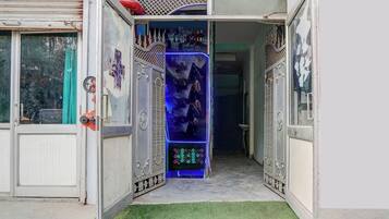 An open doorway with a decorative metal gate, a small step leading into a room, and a green artificial turf floor.