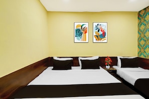 A hotel room with a large bed, two bedside tables, and two framed abstract paintings on the wall. - Hotel O James Street Railway Station (Hyderabad)