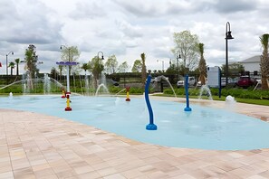 En swimmingpool med flere vandfald og en belagt sti.