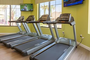 Four treadmills in a gym with large windows and a TV mounted on the wall. - 5BR Storey Lake Home, Sleeps 12 (Kissimmee)