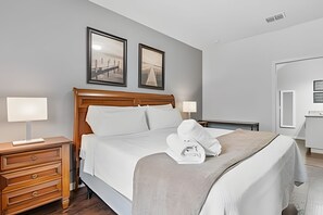Ein Hotelzimmer mit einem hölzernen Bett, zwei Nachttischlampen, einem Nachttisch, einer Holzkommode und zwei gerahmten Bildern an der Wand.