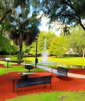 A park with a fountain, benches, and a red pathway. - 3BR Lucaya Village Home Near Disney (Kissimmee)