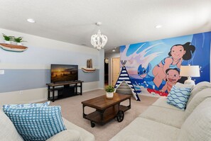A living room with a television, a coffee table, and a sofa. - 6BR Family Home With Pool and Game Room (Kissimmee)