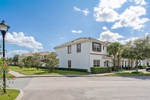 A two-story residential building with a white exterior, multiple windows, and a flat roof. - 5br/4ba Villa Sleeps 12 Private Pool & Spa (Kissimmee)
