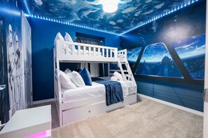A bunk bed room with a starship-themed mural, a white bunk bed, and a desk with a lamp. - 5BR Themed Villa w/ Private Pool (Clermont)