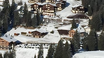 En snötäckt bergsby med flera byggnader i chaletstil.