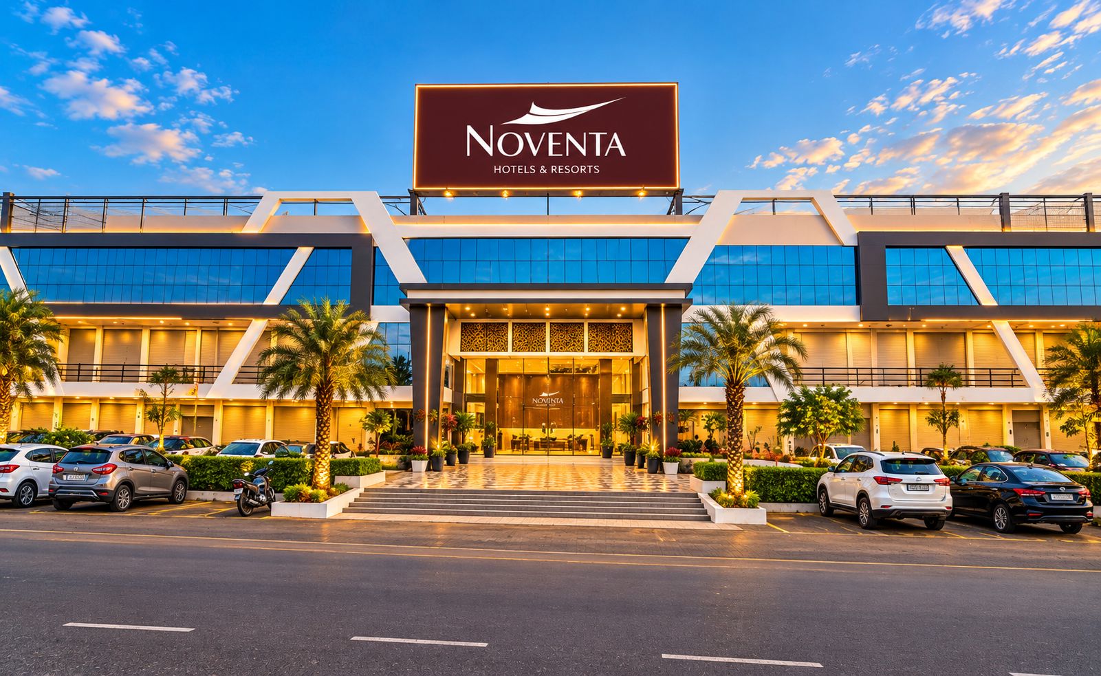 Ein Gebäude von Noventa Hotels & Resorts mit modernem architektonischen Design, das einen markanten Eingang und einen Parkplatz mit mehreren Autos zeigt.