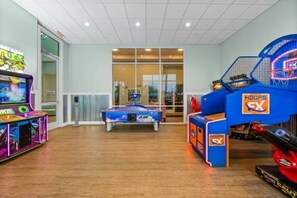 An indoor arcade with various gaming machines, including a pool table and basketball hoops. - 5BR Windsor Island Home w/ Private Pool (Davenport)